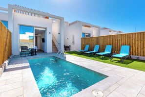 A modern outdoor pool area with a clear blue pool, lounge chairs, and a wooden fence. - Resort Cordial Santa Agueda & Perchel Beach Club (San Bartolomé de Tirajana)
