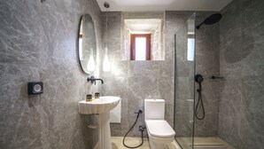 A modern bathroom with a pedestal sink, toilet, and glass-enclosed shower. - Asion Suite Eros with Private Pool (Kato Asites)
