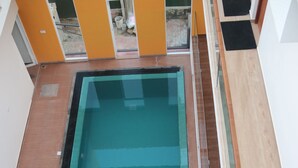 A rectangular swimming pool with a wooden deck surrounding it. - Meth Suites (Uswetakeiyawa)