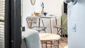 Een eetgedeelte met een ronde tafel, stoelen en een kleine decoratieve plant.