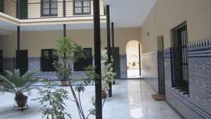 A spacious courtyard with a high ceiling, potted plants, and a tiled floor. - Central and cozy apartment in Seville - Wifi (Sevilla)