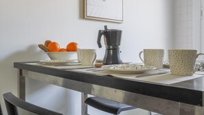A kitchen counter with a coffee maker, a bowl of oranges, and two mugs. - Pure Sevilla - Arenal - 2 bed common terrace 5 px (Sevilla)