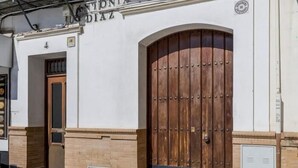 A building facade with a large wooden door, a Coca-Cola branded sign, and a sign reading "ANTONIA RODRIGUEZ DIAZ". - Pure Sevilla - Arenal - 2 bed common terrace 5 px (Sevilla)