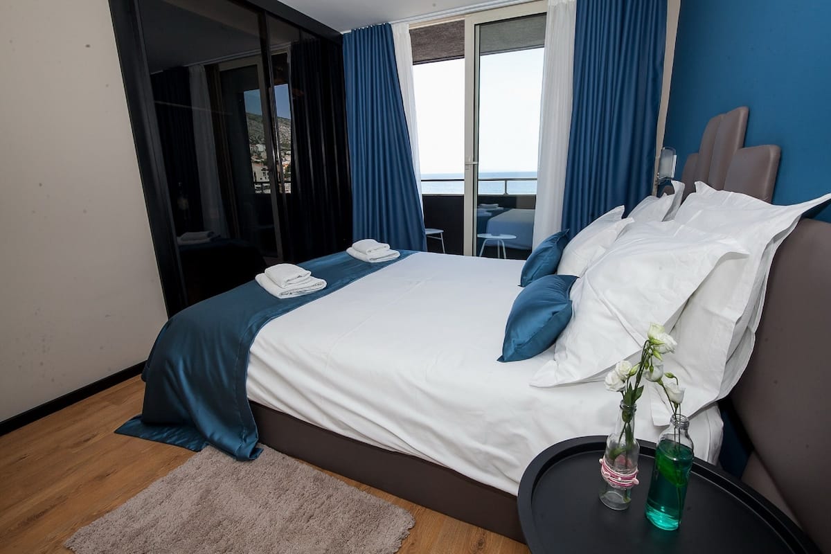 Une chambre d’hôtel moderne avec un grand lit, une vue sur la mer et un balcon.