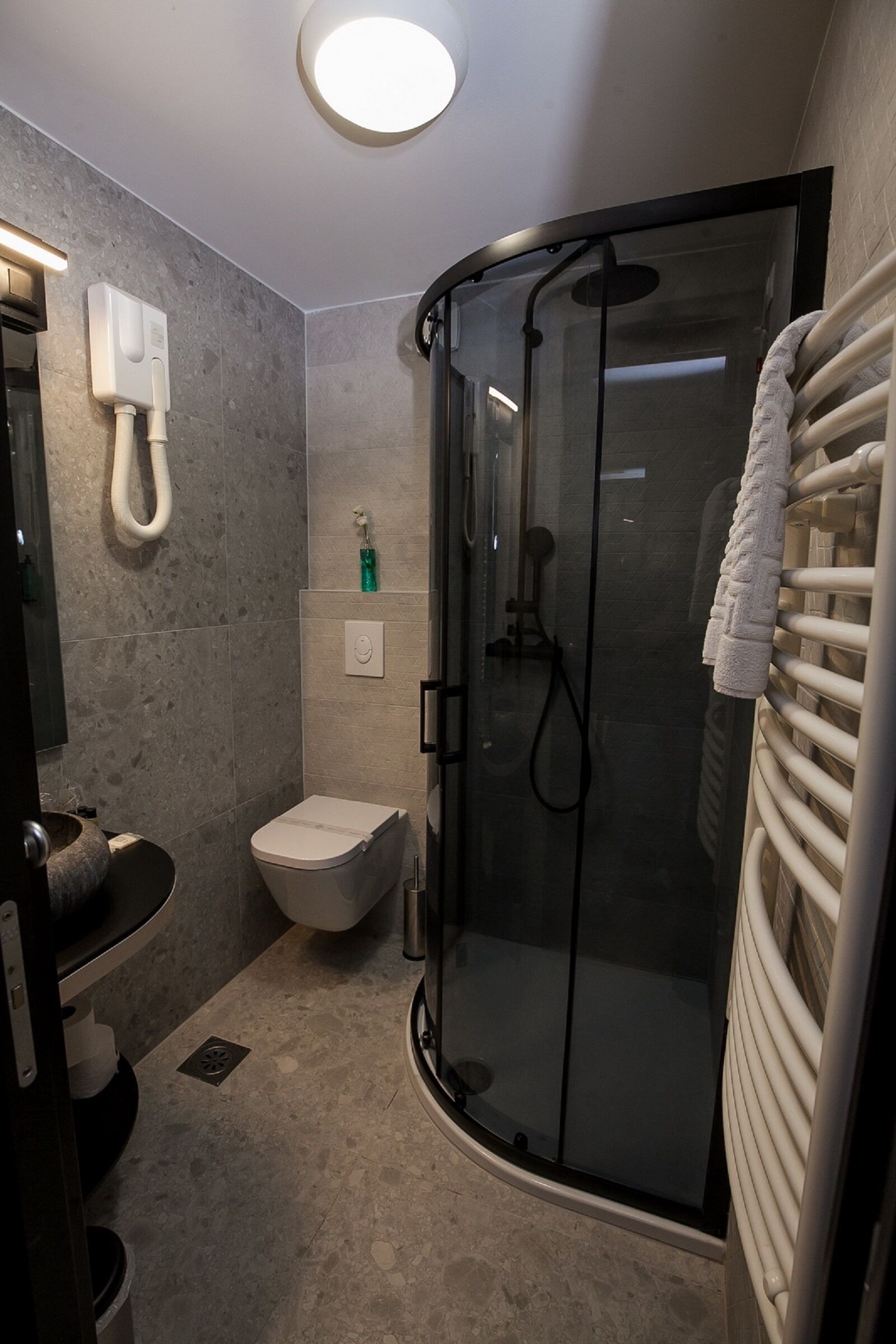 Un baño moderno con ducha de vidrio, inodoro y lavamanos.