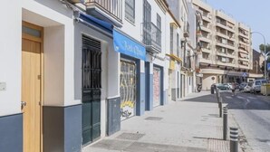 Une vue de rue avec un bâtiment doté d’une marquise bleue et d’une porte.