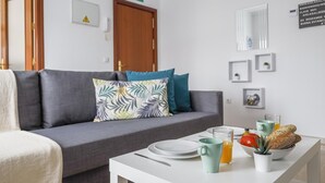 A modern living room with a grey sofa, a white coffee table, and a breakfast setup with plates, a mug, and a glass of orange juice. - Apt high qualities 2 bedrooms Alcalá del Rio (Alcalá del Rio)