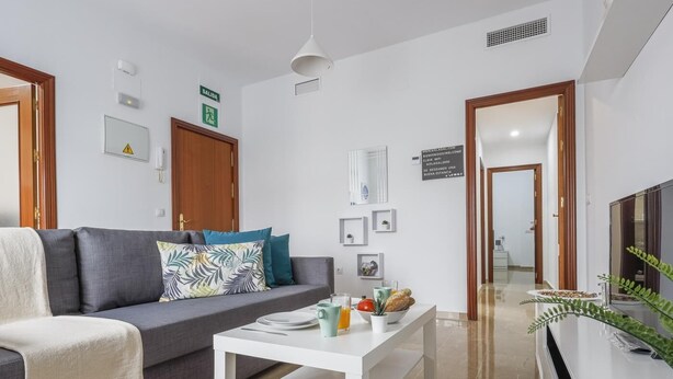 A modern living room with a grey sofa, a white coffee table, and a television on a white stand. - Apt high qualities 2 bedrooms Alcalá del Rio (Alcalá del Rio)