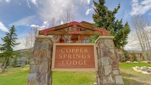 A lodge sign with the name "Copper Springs Lodge" mounted on a stone structure. - Amazing Copper Springs Condo With Awesome Views - CS221 by Redawning (Copper Mountain)