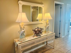 A console table with two lamps, a mirror, and decorative vases. - Elegant Egret 4 Bedroom Home by RedAwning (Supply)