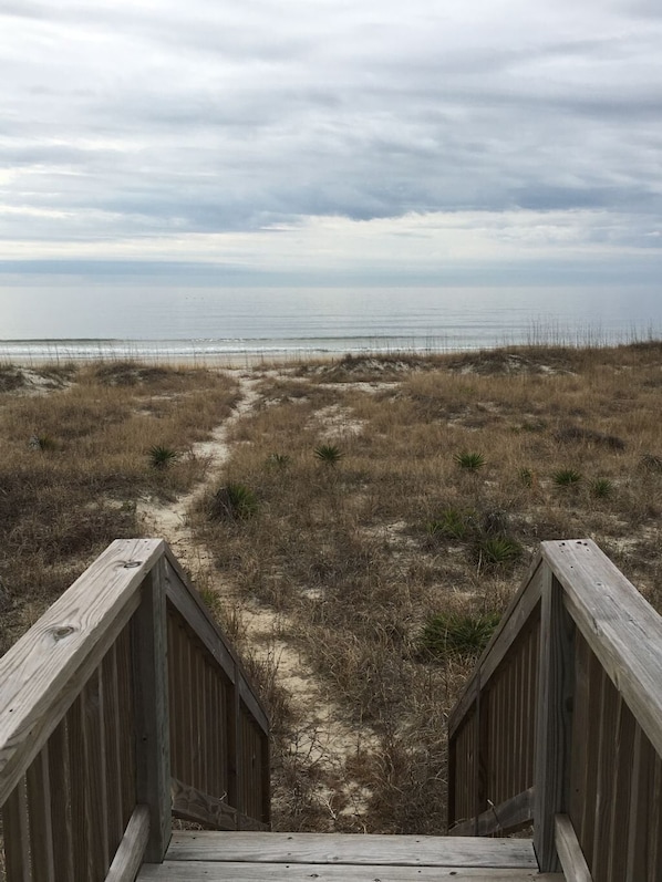 A wooden boardwalk leading to a beach with a cloudy sky. - Almost Heaven 4 Bedroom Home by RedAwning (Supply)
