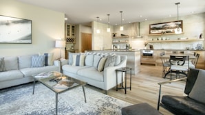 A modern living room with a sofa, coffee table, and a dining area with chairs and a table. - Sunvail S 24d 3 Bedroom Condo by RedAwning (Vail)