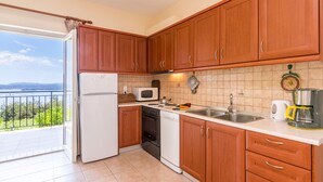 Une cuisine avec des meubles de rangement en bois, un réfrigérateur blanc, un four à micro-ondes, une cuisinière et un lave-vaisselle.