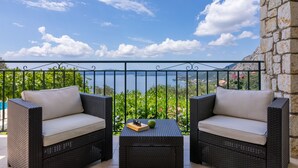 Un balcon doté de meubles en osier et offrant une vue sur un lac.