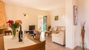 A living room with a sofa, a dining table with chairs, a TV, and a fireplace. - Villa Marianthi with private pool  (2 Bedrooms, Sleeps 4) (Corfu, Peloponnisos Dytiki Ellada ke Ionio)