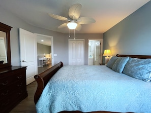 Quarto com cama, escrivaninha e cômoda.