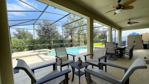 A covered outdoor area with a pool, seating, and a ceiling fan. - Private Pool Oasis!  Ultimate Family Vacation! Solterra Resort Near Disney! (Davenport)