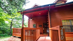 Eine Holzhütte mit Veranda, Briefkasten und einer Willkommensschild.