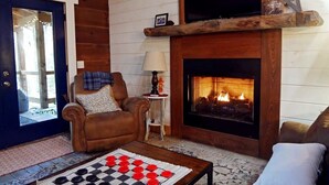 A cozy living room with a fireplace, a chessboard, and a comfortable armchair. - Rocky Top Retreat-Decorated for Christmas Near NPS (Victor)