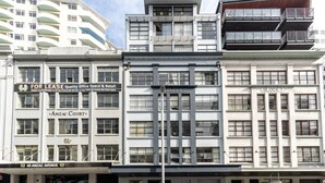 A multi-story building with commercial spaces on the ground floor, including a 'For Lease' sign, 'Anzac Court' signage, and 'Block 7' designation. - Cosy at The Cambridge Apt with Wi-Fi and Netflix (Auckland CBD)
