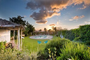 Una piscina al aire libre de temporada, sombrillas