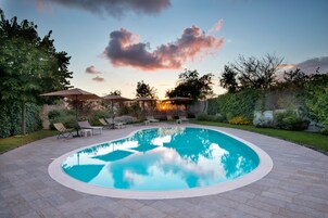 Una piscina al aire libre de temporada, sombrillas