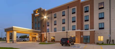 A hotel with a modern design, featuring a covered entrance and multiple floors.