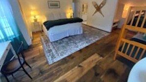 A bedroom with a bed, a desk, and a chair. - Deluxe King, Living Room w/sofa bed, bunk bed & fireplace (Dover)