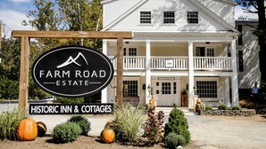 Ein historisches Gasthaus und Ferienhäuser mit einem Schild für Farm Road Estate.