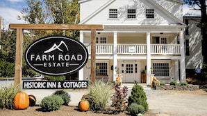 Una posada histórica y cabañas con un letrero que dice Farm Road Estate.