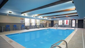 An indoor swimming pool with clear water, blue chairs, and a lifeguard sign. - Home2 Suites by Hilton Springdale Cincinnati (Cincinnati)