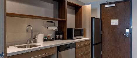 A modern kitchen with a built-in dishwasher, a microwave, and a refrigerator.