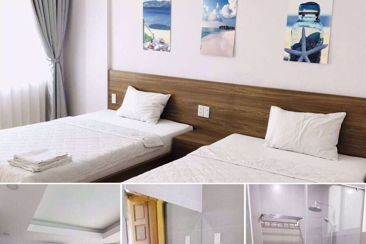 Ein Hotelzimmer mit zwei Betten, einem Badezimmer mit einem großen Spiegel, einem Waschbecken und einer Dusche.