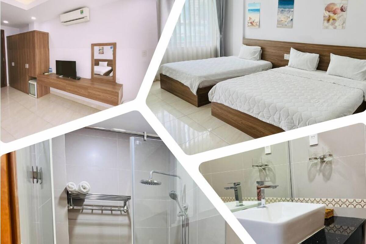 Ein Hotelzimmer mit Bett, Nachttisch, Klimaanlage, Dusche und einem Badezimmer mit Waschbecken und Spiegel.