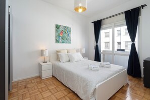 Relax in a serene space with a comfortable bed, a nightstand, and a beautiful wall art.