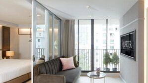 Ein modernes Hotelzimmer mit einem Bett, einer Couch und einem kleinen Couchtisch.