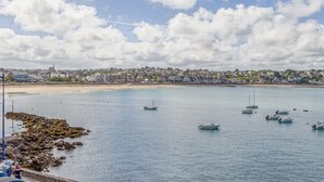 A coastal town with a sandy beach, calm water, and several boats. - LE MATELOT 3* - Superbe appartement vue mer - Erquy (Erquy)