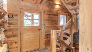 Un intérieur en bois, avec une porte en bois, un escalier et une fenêtre.