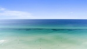 A beach with clear turquoise water and a sandy shore.