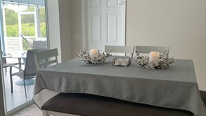 A dining area with a table set for two, a bench, and a chandelier. - Heated pool for Your next vacation getaway! (North Port)
