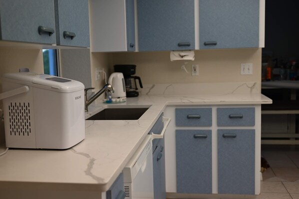 Una kitchenette con una cafetera Bosch, un tostador y armarios azules.