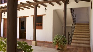 A covered outdoor area with a wooden pergola, a staircase, and potted plants. - La Buganvilla Barichara (Barichara)