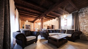 A rustic living room with exposed wooden beams, stone walls, and leather sofas. - Holiday home Mare (Petrcane)