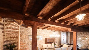 A rustic dining area with a wooden staircase, stone walls, and a chandelier. - Holiday home Mare (Petrcane)