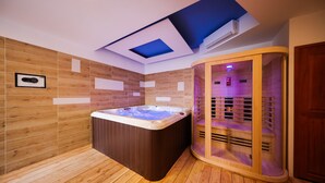 A modern bathroom with a wooden floor, a freestanding hot tub, and a glass-enclosed sauna. - Holiday home Mare (Petrcane)