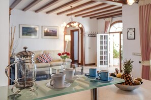 A dining area with a coffee pot, cups, and a fruit bowl on a glass table. - Beachfront Ground-Floor Villa w/ Pool & BBQ (Playa Honda)