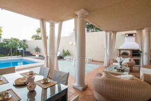 An outdoor patio with a pool, dining area, and a barbecue setup. - Beachfront Ground-Floor Villa w/ Pool & BBQ (Playa Honda)