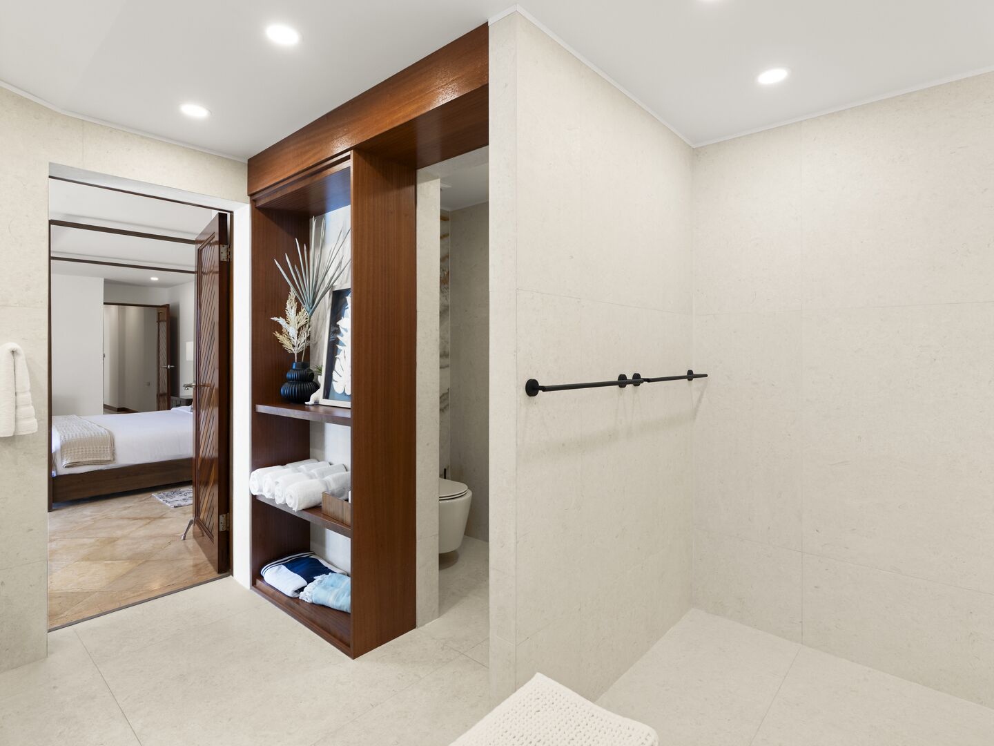 A modern bathroom with a walk-in shower, a wooden vanity, and a large mirror.