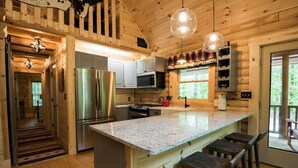 A wooden cabin kitchen with a stainless steel refrigerator, a microwave, and a sink. - Secluded, pet-friendly, new log cabin. (Morgantown)
