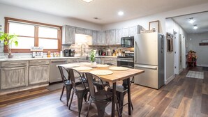 A modern kitchen with a central island, wooden cabinets, and stainless steel appliances. - Pet-friendly, renovated, walk to downtown. (Nashville)